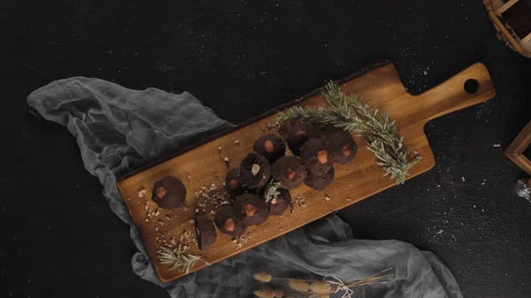 ダークチョコレートトリュフとともにヘーゼルナッツ上の木のまな板 — ストック写真