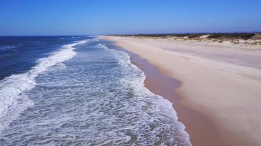 Beyaz kum plaj kıyısında, 4 k dron görüntüleri ve dışarı inişli çıkışlı dalgalar üzerinde boyunca uçan düşük.