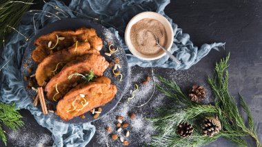 Traditional Christmas Rabanadas with lemon zest, raisins, pine nuts and cinnamon. Spanish Torrijas or french toasts close up on the countertop