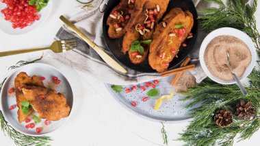 Traditional Christmas Rabanadas with pommegranate seeds, pine nuts and cinnamon. Spanish Torrijas or french toasts close up on the countertop.