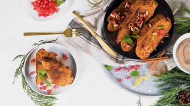 Traditional Christmas Rabanadas with pommegranate seeds, pine nuts and cinnamon. Spanish Torrijas or french toasts close up on the countertop.