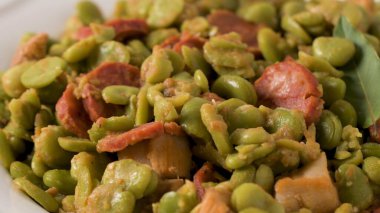 Haşlanmış geniş fasulye chorizo ve defne ile beyaz seramik tabak içinde bırakır. Tipik Portekizce gıda.