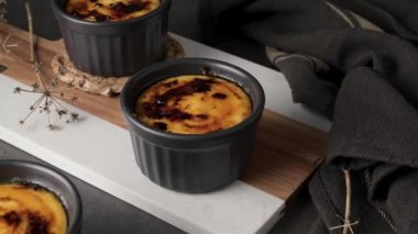 Creme brulee. Üzerinde karamelli şeker, kaşıklar, koyu kırsal masa olan Fransız vanilyalı tatlı kaseleri..