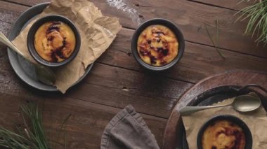 Creme brulee. Üzerinde karamelli şeker, kaşıklar, koyu kırsal masa olan Fransız vanilyalı tatlı kaseleri..