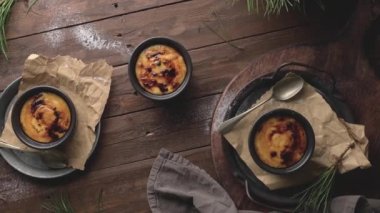 Creme brulee. Üzerinde karamelli şeker, kaşıklar, koyu kırsal masa olan Fransız vanilyalı tatlı kaseleri..