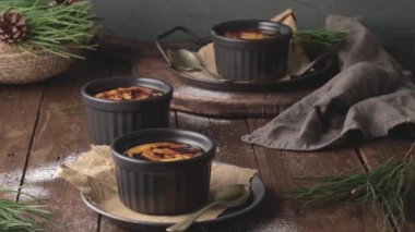 Creme brulee. Üzerinde karamelli şeker, kaşıklar, koyu kırsal masa olan Fransız vanilyalı tatlı kaseleri..