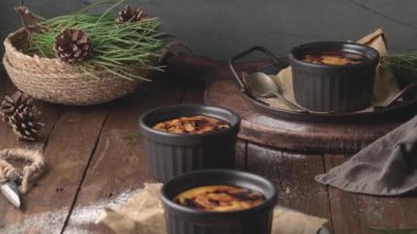 Creme brulee. Üzerinde karamelli şeker, kaşıklar, koyu kırsal masa olan Fransız vanilyalı tatlı kaseleri..