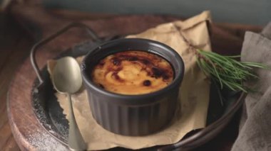 Creme brulee. Üzerinde karamelli şeker, kaşıklar, koyu kırsal masa olan Fransız vanilyalı tatlı kaseleri..