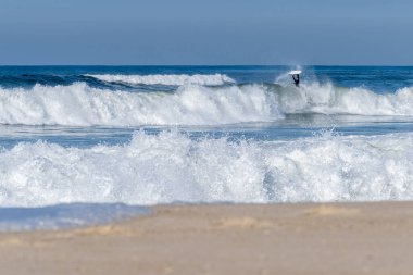 Güneşli bir kış gününde sörf yapan sörfçü..