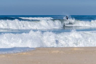 Güneşli bir kış gününde sörf yapan sörfçü..