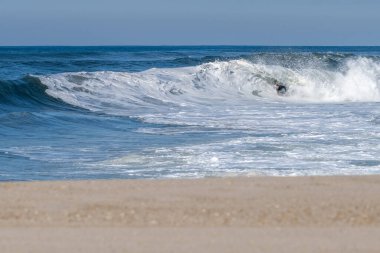 Güneşli bir kış gününde sörf yapan sörfçü..