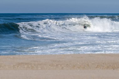 Güneşli bir kış gününde sörf yapan sörfçü..