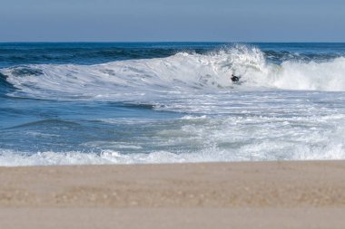 Güneşli bir kış gününde sörf yapan sörfçü..