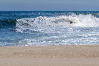 Güneşli bir kış gününde sörf yapan sörfçü..