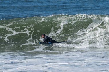 Güneşli bir kış gününde sörf yapan sörfçü..