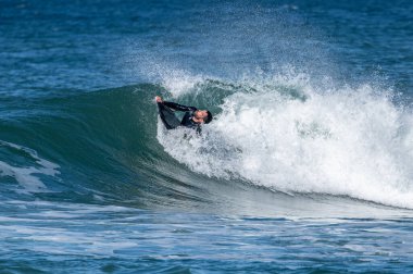 Güneşli bir kış gününde sörf yapan sörfçü..