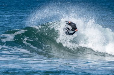Güneşli bir kış gününde sörf yapan sörfçü..