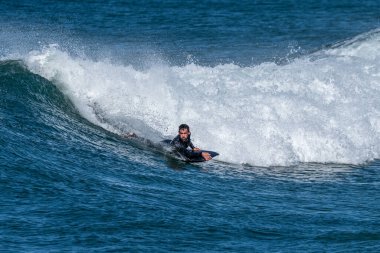 Güneşli bir kış gününde sörf yapan sörfçü..