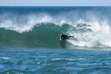 Güneşli bir kış gününde sörf yapan sörfçü..