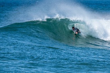 Güneşli bir kış gününde sörf yapan sörfçü..