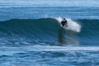 Güneşli bir kış gününde sörf yapan sörfçü..