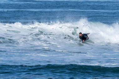 Güneşli bir kış gününde sörf yapan sörfçü..