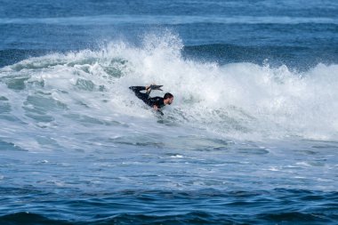Güneşli bir kış gününde sörf yapan sörfçü..