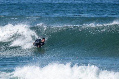Güneşli bir kış gününde sörf yapan sörfçü..