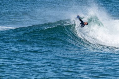 Güneşli bir kış gününde sörf yapan sörfçü..