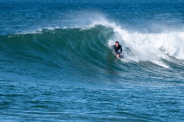 Güneşli bir kış gününde sörf yapan sörfçü..