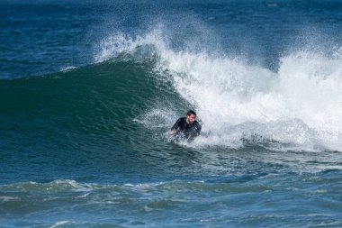 Güneşli bir kış gününde sörf yapan sörfçü..