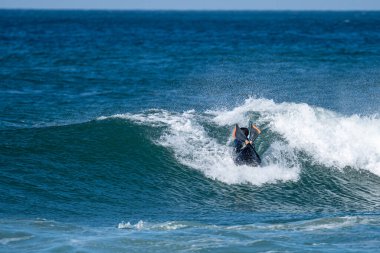 Güneşli bir kış gününde sörf yapan sörfçü..