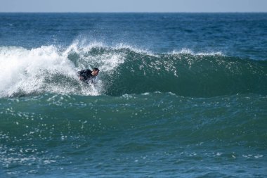 Güneşli bir kış gününde sörf yapan sörfçü..