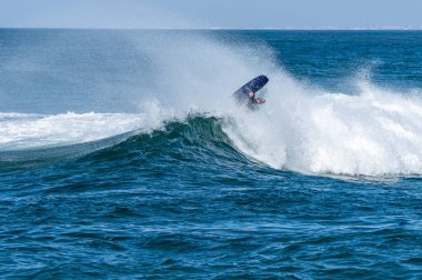 Güneşli bir kış gününde sörf yapan sörfçü..