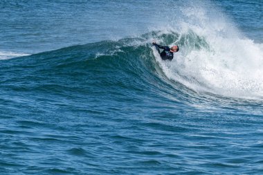 Güneşli bir kış gününde sörf yapan sörfçü..