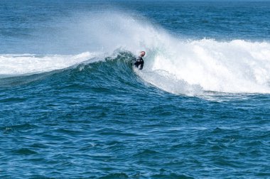 Güneşli bir kış gününde sörf yapan sörfçü..