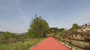 VOUZELA, PORTUGAL - CIRCA Nisan 2023: Vouzela 'nın ekotrinde bisiklet sürme görüntüsü, Portekiz. Bisiklet pistine ve doğal manzaraya geniş bir açıdan bakıyor..