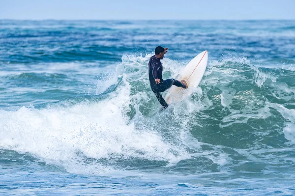 ポルトガルのFuradouro Beachで波に乗ってください 海で波を引く男たち サーフィンアクションウォーターボードスポーツ 人々は夏休みにスポーツレッスンやビーチスイミング活動をしています — ストック写真