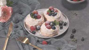 Taze ahududu ve yaban mersini ile küçük pavlova kek.