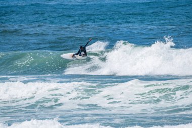 Genç sporcu Portekiz 'in Ovar kentindeki Furadouro Sahili' nde sörf yapıyor..
