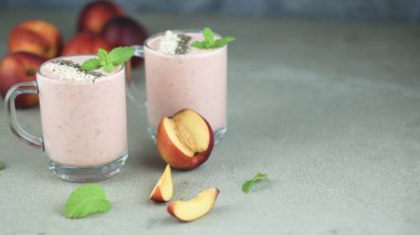 Çilek ve şeftali smoothie beton tezgah üzerinde kavanozların içinde. Protein kokteyl. Sağlıklı içecek. Taze ev yapımı güler yüzlü. Sağlıklı kahvaltı güler yüzlü.