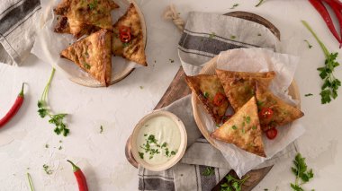 Hint samosaları - kızarmış ya da fırında hamur tatlısı ve baharatlı mutfak tezgahında areca yaprağı tabağında servis edilen lezzetli Hint yemekleri..