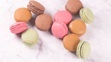 Fransa gelen macarons Bademli kurabiye kurabiye tatlı bir beyaz mermer tezgah üzerinde izole.