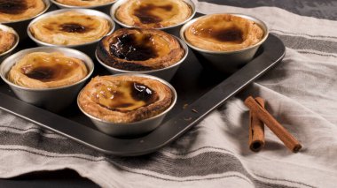 Satırları yeni pişirilmiş yumurta tart, geleneksel Portekiz tatlı, pastel de nata, kremalı tart metal tepsi.