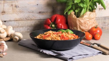 Ton balığı ve fesleğen ile İtalyan makarna. Eski ahşap arka plan üzerinde ton balığı ve domates soslu makarna.