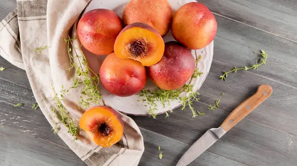 stock image Plate with fresh nectarines on wooden table.