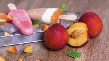 Ev yapımı Ahududu ve ahşap bir masa üzerinde şeftali popsicles.