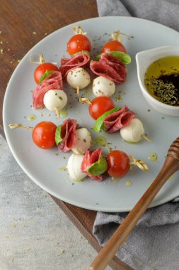 İtalyan usulü aperatif, antipasto şiş ya da fesleğen, salam, mozarella ve domatesli bir çubukta caprese..