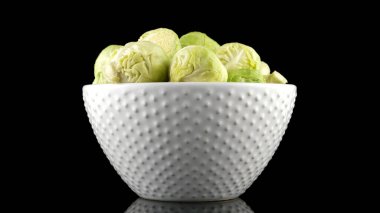 Taze Brüksel lahanası izole siyah arka plan üzerine beyaz seramik kupa.