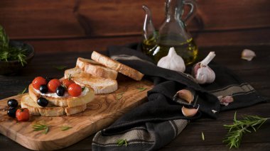 Krem peynirli taze bruschetta, siyah zeytin ve vişneli domates yakından..